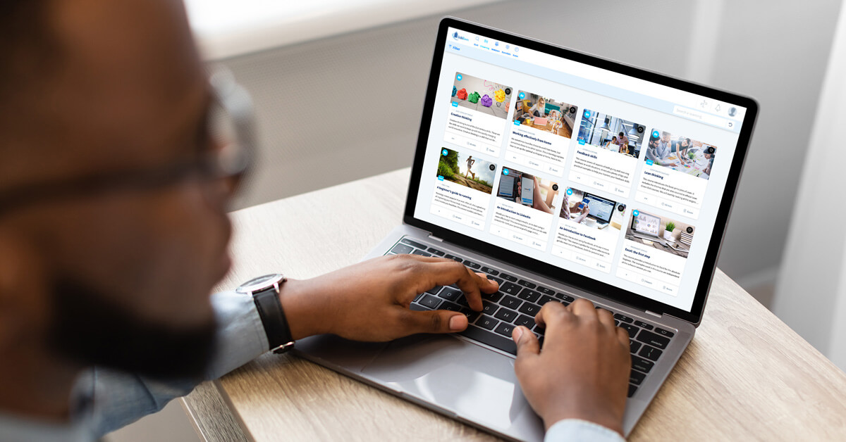 A man looking at a laptop displaying online learning content in the online learning platform of SkillsTown.